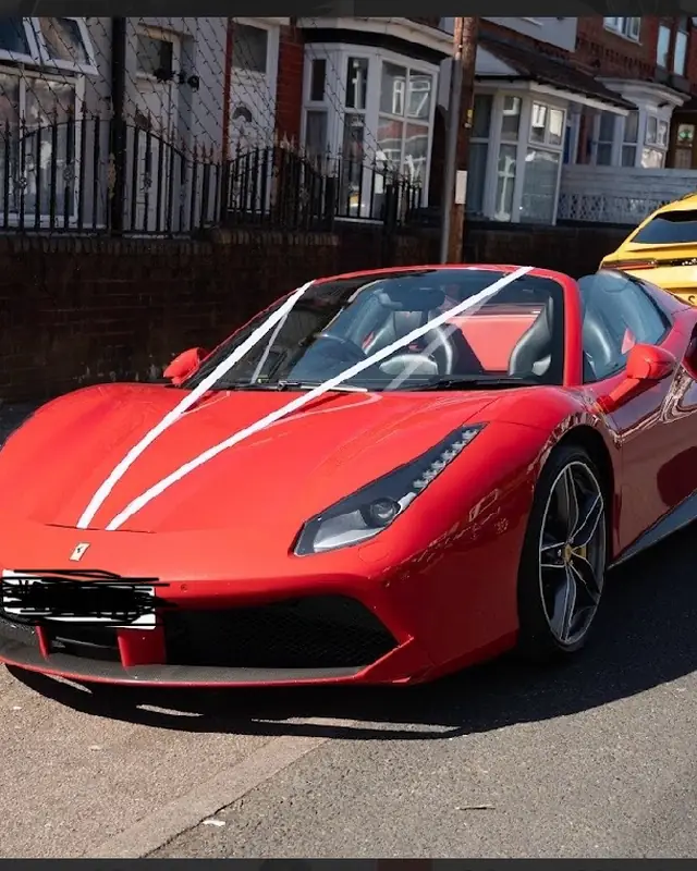 Red Ferrari dressed with white wedding ribbons