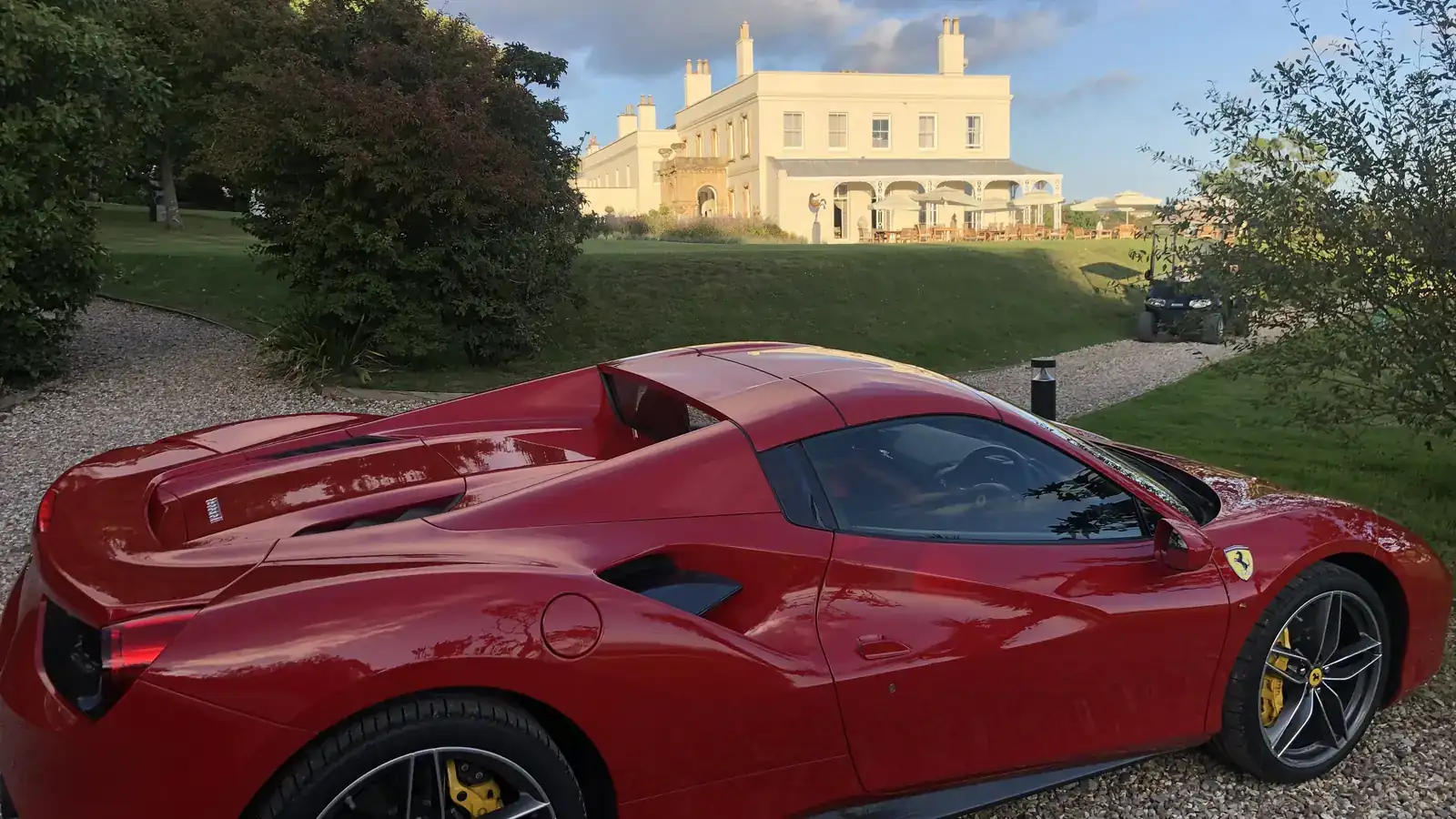Red Ferrari 488 Spider outside a country house at golden hour