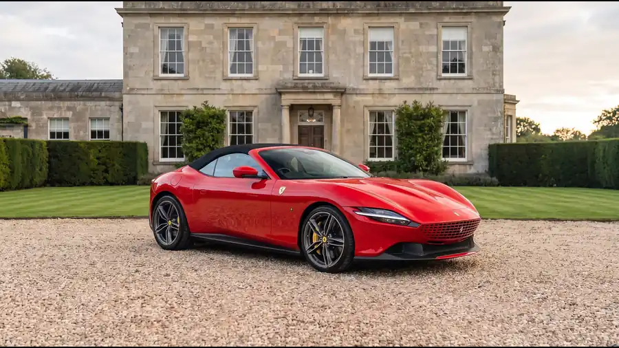 Red Ferrari Roma Spider on the gravel drive of an English country house