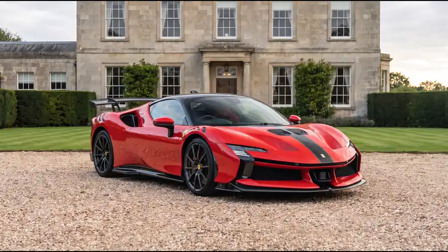 Red Ferrari SF90 XX on the gravel drive of an English country house