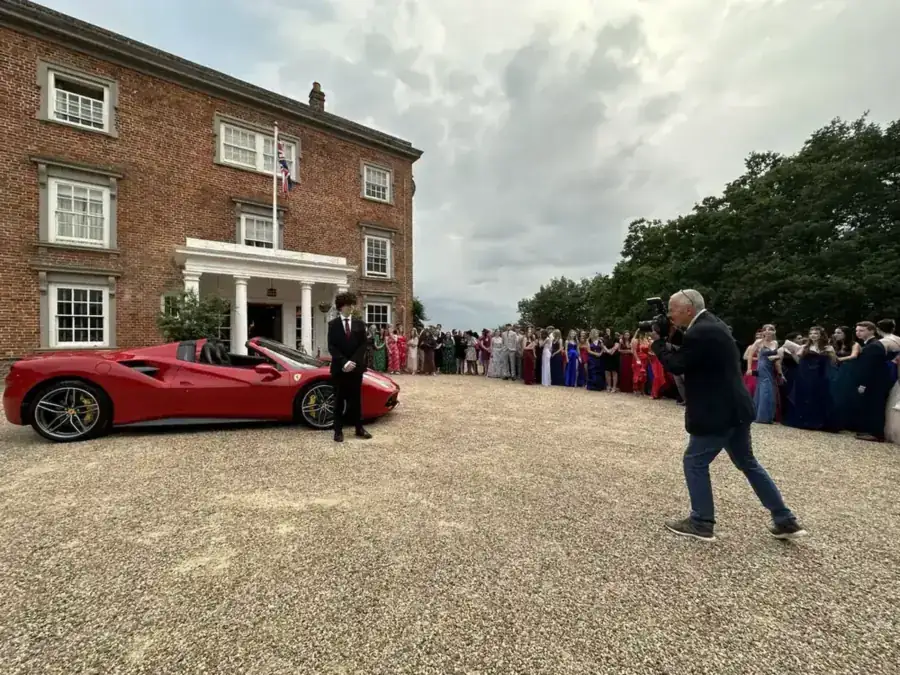 A Ferrari 488 Spider arriving at a school prom as a photographer takes pictures
