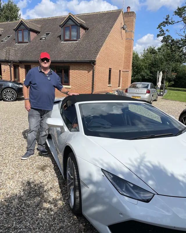 A customer beside a white Lamborghini Huracán Spyder for his 65th birthday