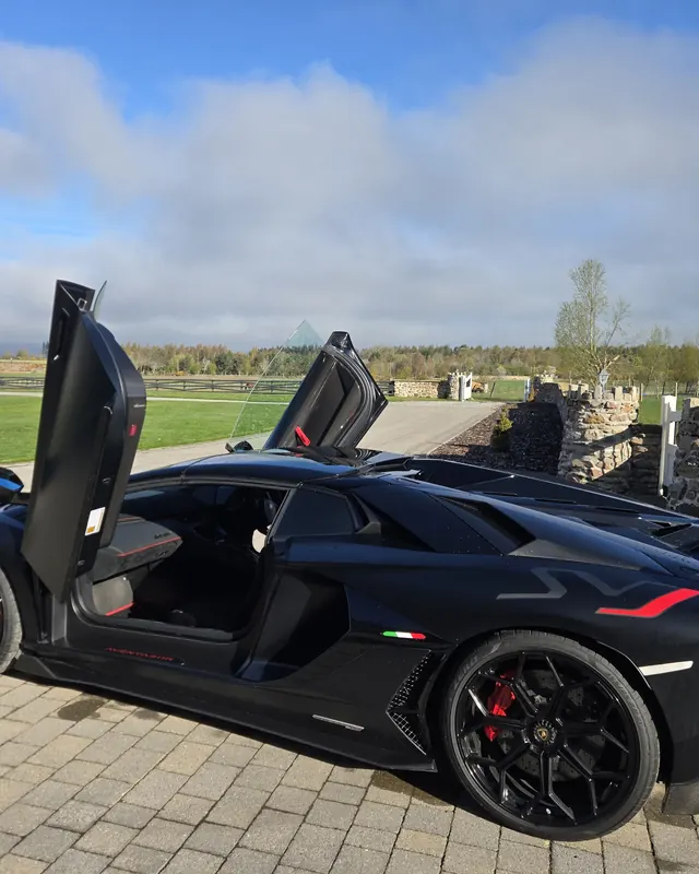 Black Lamborghini Aventador SVJ with its scissor doors up, hired for a 40th birthday
