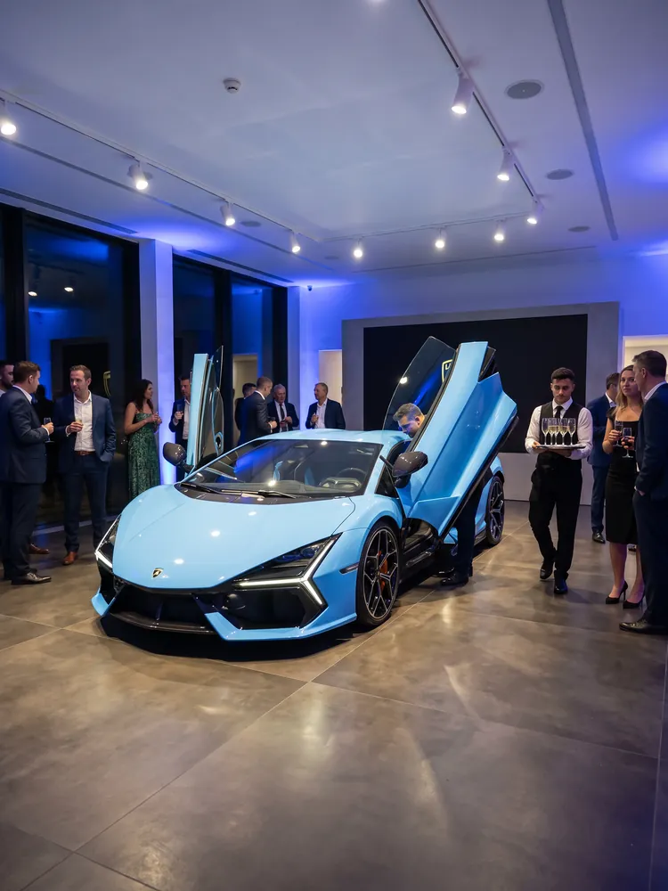 A blue Lamborghini Revuelto with its doors up at a launch event