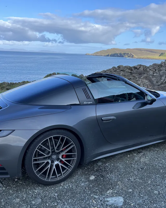 Grey Porsche 911 Targa beside the sea in Scotland