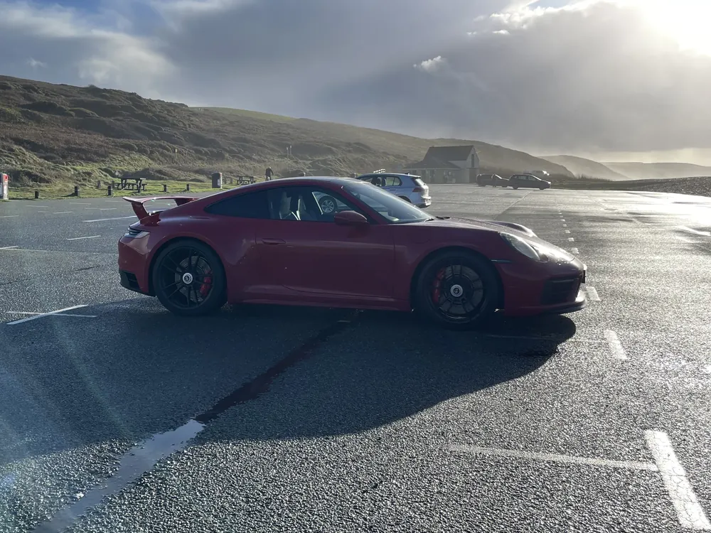 Red Porsche 911 GTS by the sea, a surprise weekend